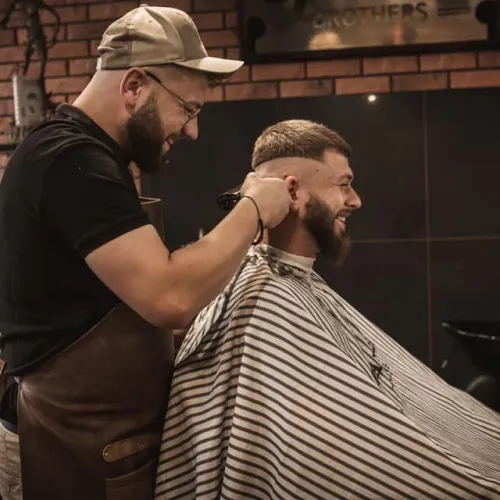 Barber strzyże klienta w salonie Barber Brothers